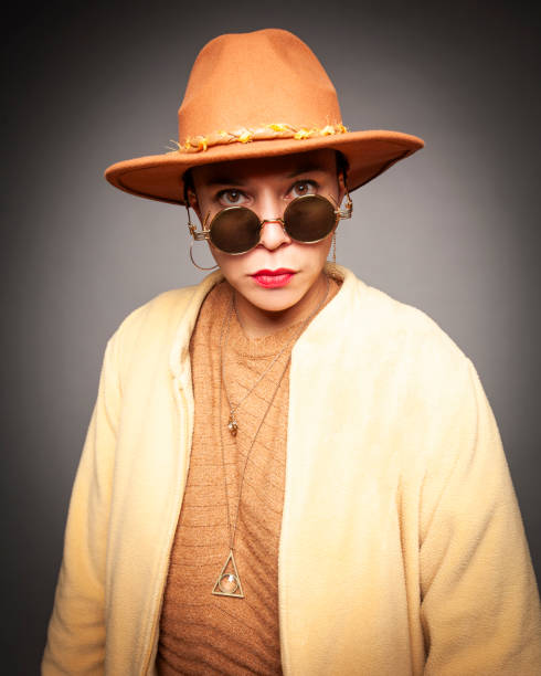 No idea. Portrait of confused clueless glamour hipster girl with violet hair in sunglasses and hat shrugging shoulders, doesn't know answer, uncertain puzzled expression. white background, studio shot