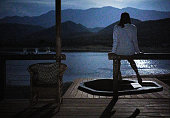 Woman looking at the scenic view from her vacation cabin at night