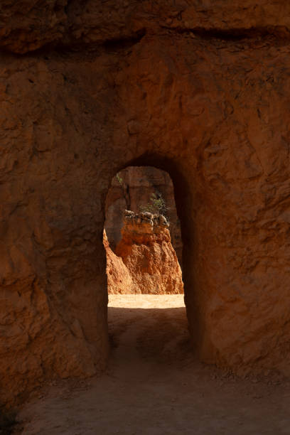 istock Small Hoodoo Framed In A Tunnel Through Thick Orange Wall 2102942509