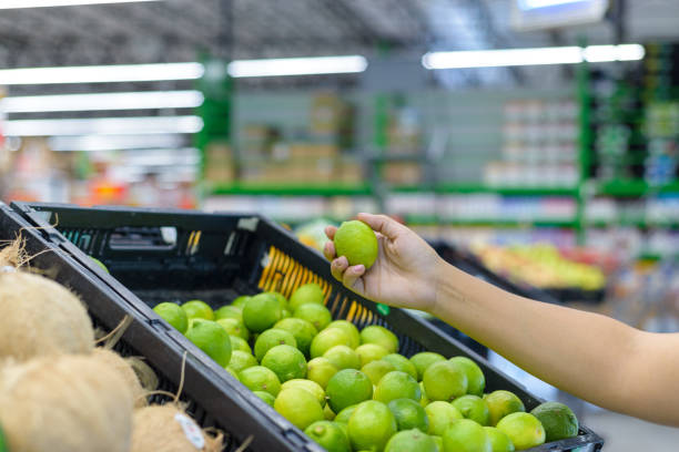 istock Hand holding a lemon in a supermarket. 2102955058