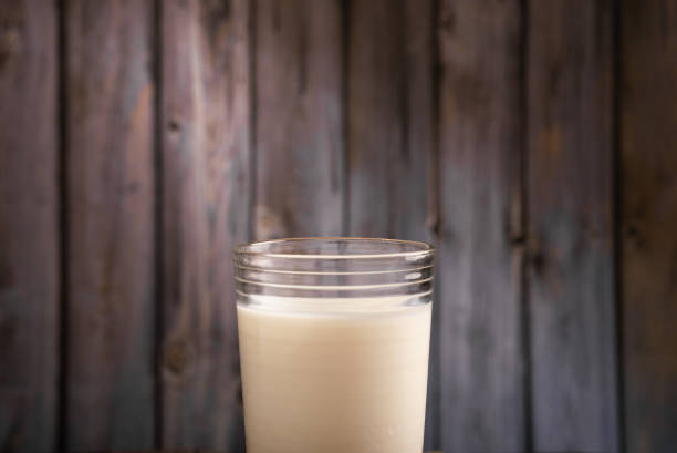 Milk glass isolated on wooden background. Copy space.