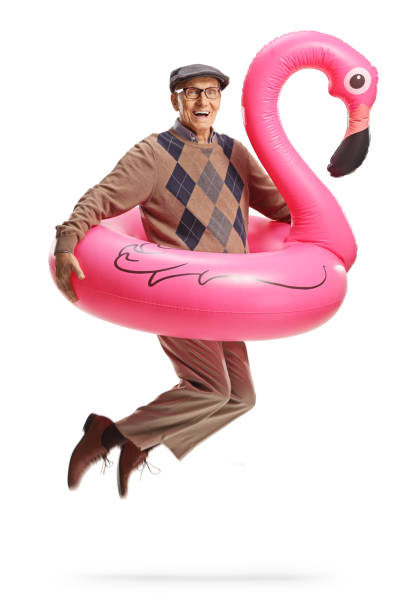 istock Elderly man jumping with a big inflatable flamingo rubber ring 2102993602
