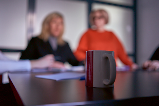 cup of coffee in the foreground during a meeting in the office