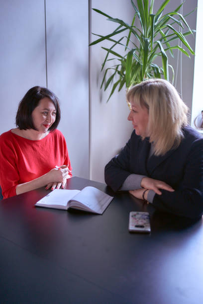 istock two women discuss strategy in the office 2102998831