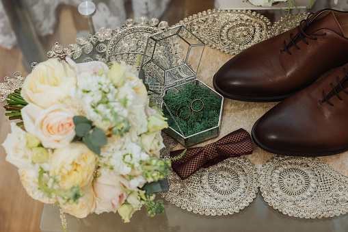 Men's accessories, groom details. Beauty is in the details. Preparation for the Wedding. Leather shoes. Gold wedding rings. Bow tie. Wedding bouquet of flowers.