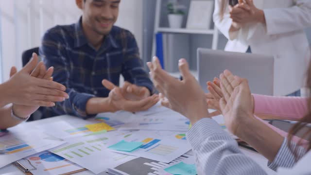 Close up hand of young businessman and businesswoman clapping together. Attractive employee worker feel happy, motivate each other and work as unity teamwork to discuss project in corporate