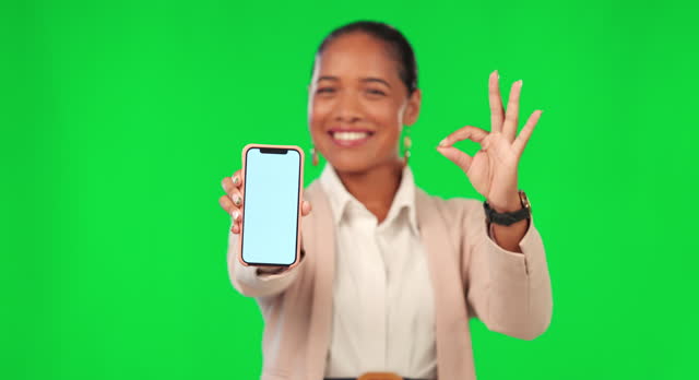 Okay sign, phone and woman on green screen for promotion, advertising mockup and success hands. Yes, excellence and happy face of business person on mobile app, ux design space and studio background