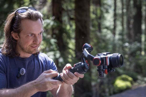 istock Young man filming with a camera gimbal 2103088180