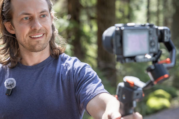 istock Young man filming with a camera gimbal 2103088707