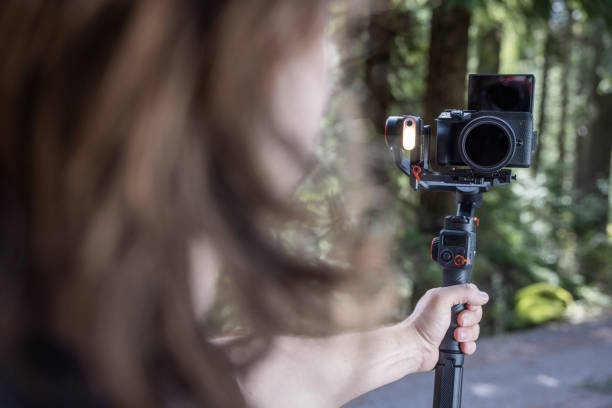 istock Young man filming with a camera gimbal 2103092372