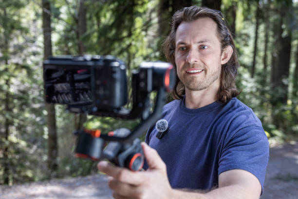 istock Young man filming with a camera gimbal 2103093919