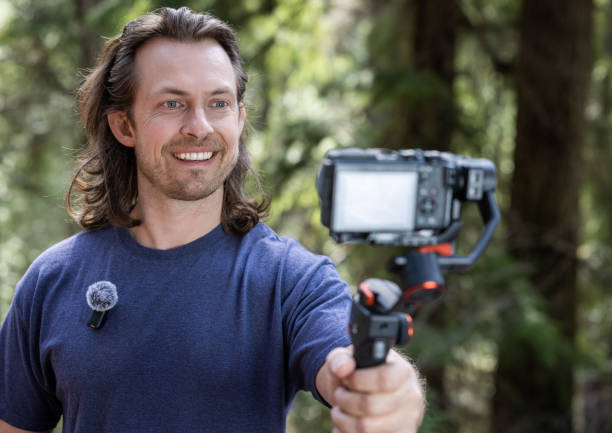 istock Young man filming with a camera gimbal 2103096006