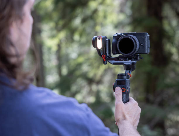 istock Young man filming with a camera gimbal 2103097050