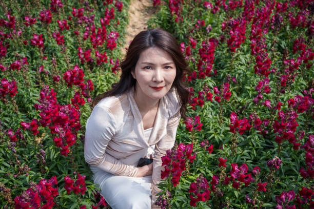 Asian woman among red flowers