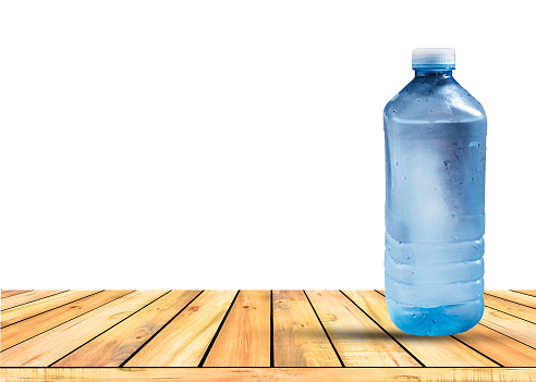 A cold water bottle  setting on wooden table isolated on white background.