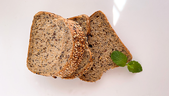 Wholegrain slice of grain bread on white background.  Top view of bread loaf.