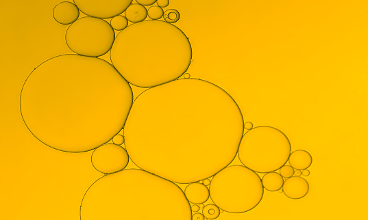 abstract oil and water bubbles pattern of an art image on golden yellow  gradient background. Ideal as app design background, template, all season sale poster etc.,.