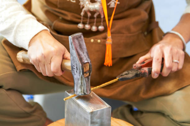 A traditional craftsman creates metal jewelry pieces