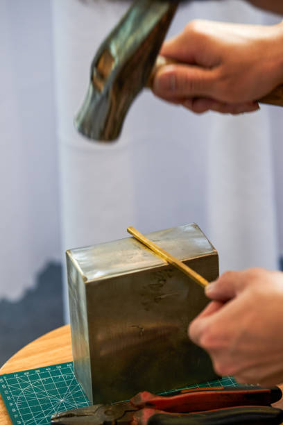 A traditional craftsman creates metal jewelry pieces