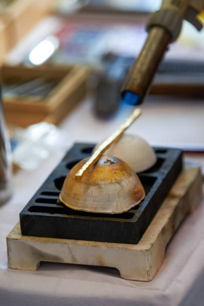 A traditional craftsman creates metal jewelry pieces