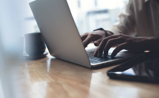 istock Man hands typing on laptop computer keyboard, online job. Business man sitting at table surfing the internet, online working at home office, telecommuting, close up 2103178864