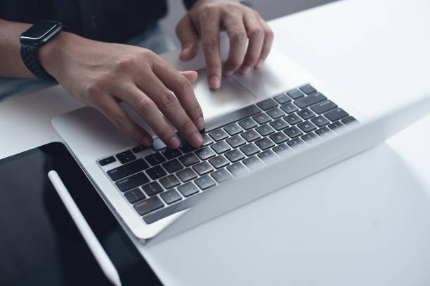 istock Business man working on laptop computer with digital tablet on table at home office, male hands typing on notebook keyboard, telecommuting, online job, working at home 2103183358