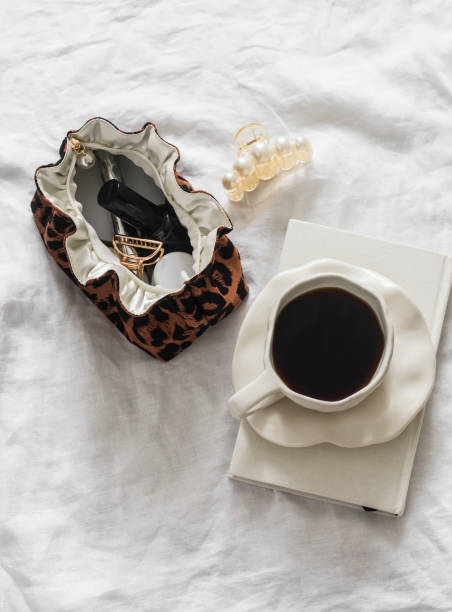 istock A cup of coffee, a notebook, a cosmetic bag on a light background, top view 2103206269
