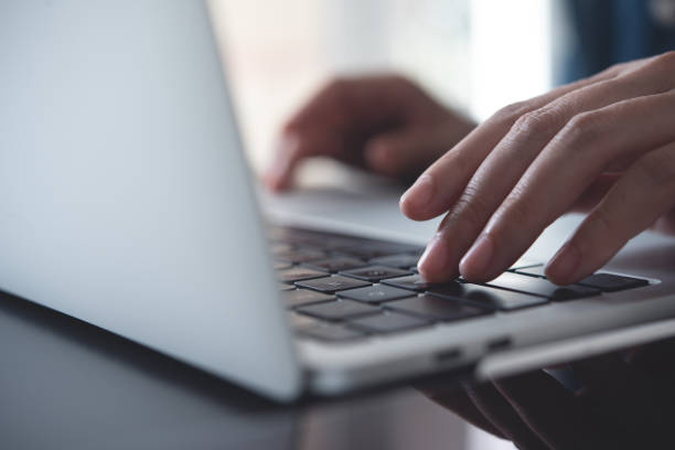 close up of business woman hands typing on laptop keyboard on table, online working from home office, searching the information on internet network, e-learning, telecommuting concept - connection e mail typing human hand ストックフォトと画像