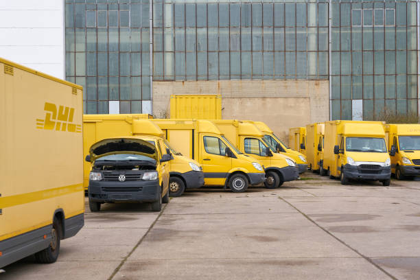 discarded dhl vehicles in the yard of a car recycler in magdeburg, germany - versand zdjęcia i obrazy z banku zdjęć