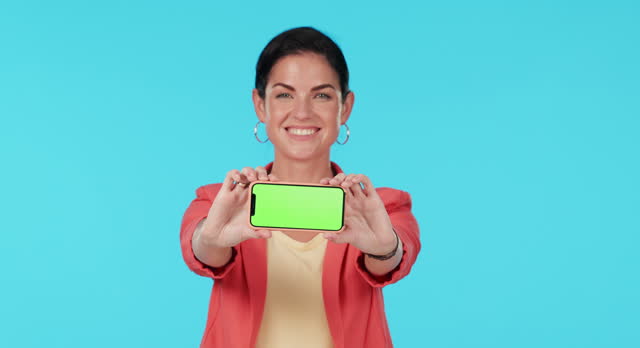 Green screen phone, face and happy woman point at mock up promotion, brand presentation and mobile application. Portrait, smartphone connection and person gesture at online service on blue background
