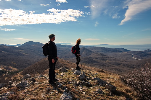 Mature couple standing on the mountain ridge