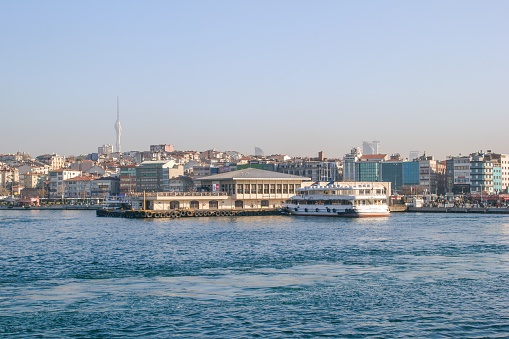 Istanbul, Turkey - December 29, 2022: Cityscape of Istanbul from the Bosphorus Strait with a boat in the foreground.