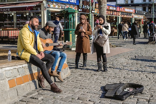 Istanbul, Turkey - December 29, 2022: Street Musician Playing Guitar for Tourists on a Cobblestone Street.