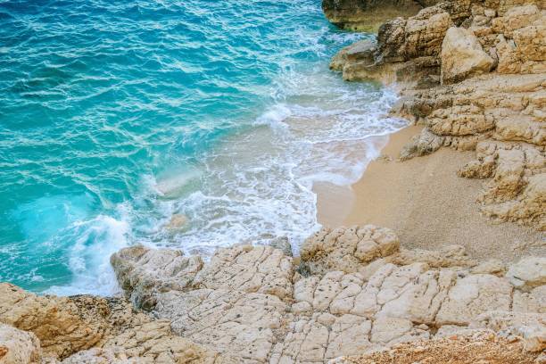 istock Small waves gently lap the shore under the bright sun. 2103315994