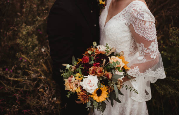 istock Bride and groom taking photos with wedding bouquet 2103316507