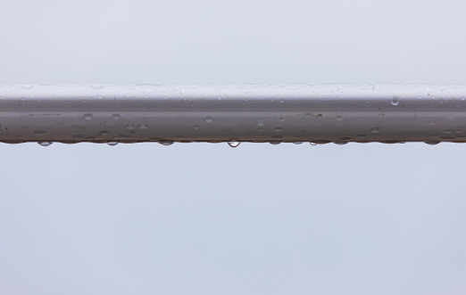 A dew-covered railing on a rainy day. close up