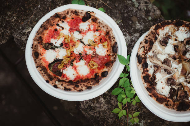 Mushroom pizza and artichoke pizza made in fire burning oven outdoors