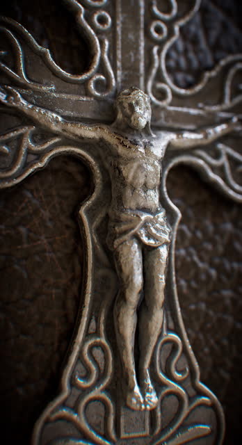 A metal cross affixed to a leather-bound religious tome