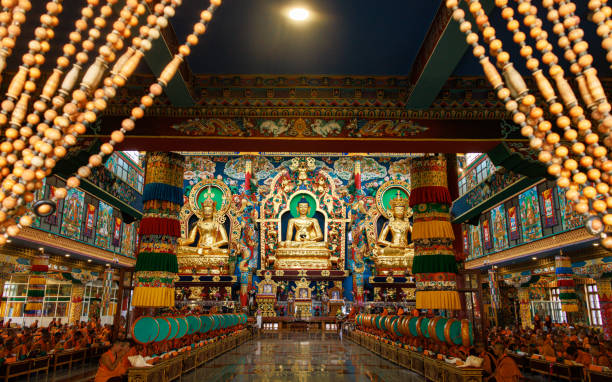 oração budista tradicional no templo dourado do mosteiro de namdroling. padmasambhava buddhist vihara também conhecido pelos moradores locais como o templo dourado em karnataka, índia. - golden temple - fotografias e filmes do acervo