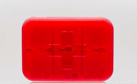 Compact red pill box organizer isolated on white background.