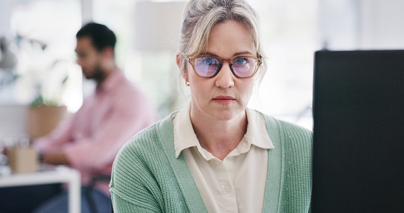 Portrait, annoyed and office for female person, burnout and tired in corporate workplace. Technology, eyewear and desk for unhappy woman receptionist, employee and mental health or frustration