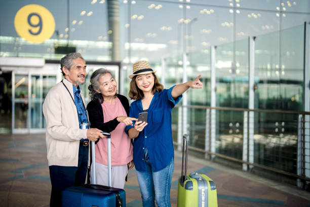 istock Ready to Journey. Young woman with family using using mobile smartphone and checking flight in international airport 2103406058