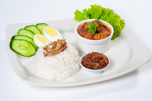 Asian Malaysia Famous Nasi Lemak with Curry Chicken, Sambal, Vegetable, Boiled Egg, Fried Fish.