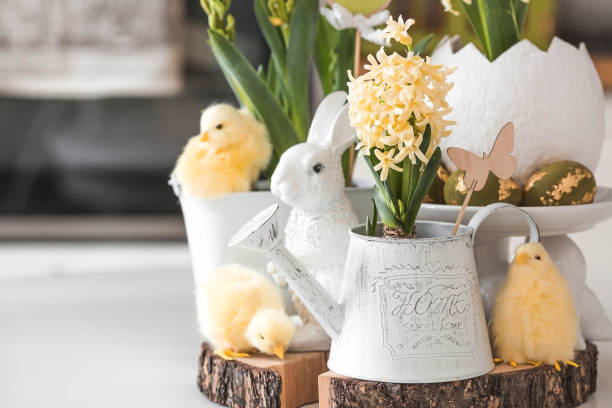 istock Happy Easter. Spring yellow hyacinth flowers in an egg-shaped vase, chicken chicks on a white table. In the background is a white Scandinavian-style kitchen. Easter decor in the house. 2103418639