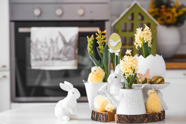 istock Happy Easter. Spring yellow hyacinth flowers in an egg-shaped vase, chicken chicks on a white table. In the background is a white Scandinavian-style kitchen. Easter decor in the house. 2103418641