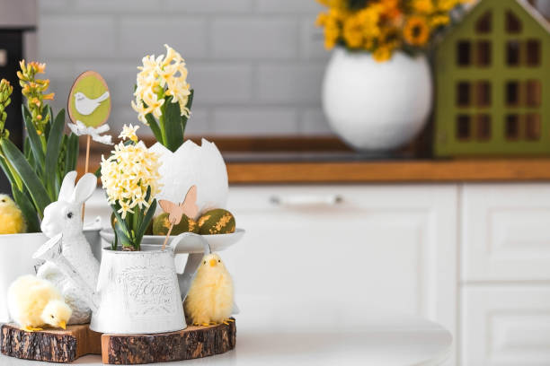istock Happy Easter. Spring yellow hyacinth flowers in an egg-shaped vase, chicken chicks on a white table. In the background is a white Scandinavian-style kitchen. Easter decor in the house. 2103418644