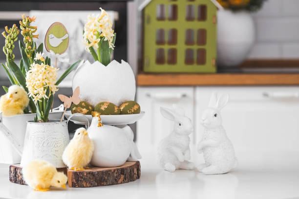 istock Happy Easter. Spring yellow hyacinth flowers in an egg-shaped vase, chicken chicks on a white table. In the background is a white Scandinavian-style kitchen. Easter decor in the house. 2103418645