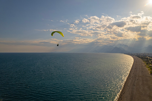 Aerial view of a paraglider flying over Konyaalti Beach, Antalya, Turkey