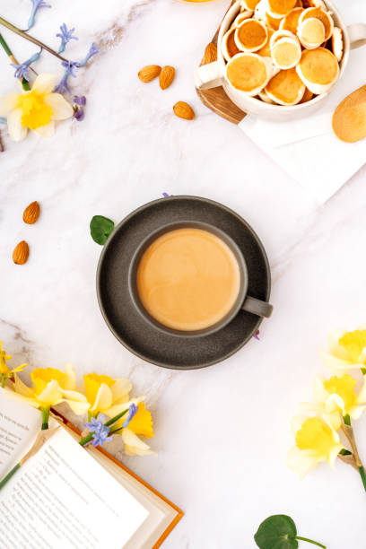 istock cup of coffee in a spring atmosphere surrounded by flowers, top view, background 2103439180