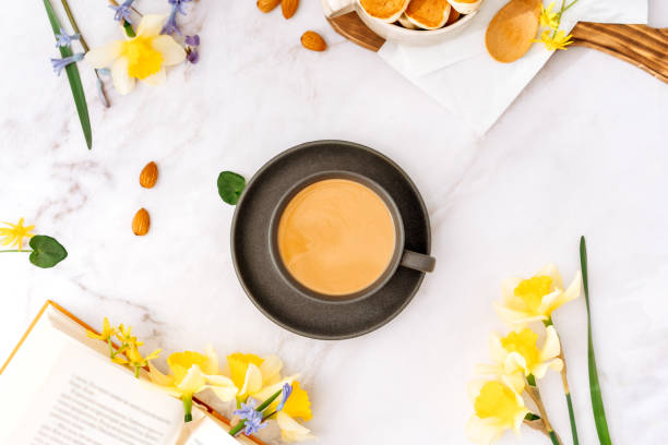istock cup of coffee in a spring atmosphere surrounded by flowers, top view, background 2103439186
